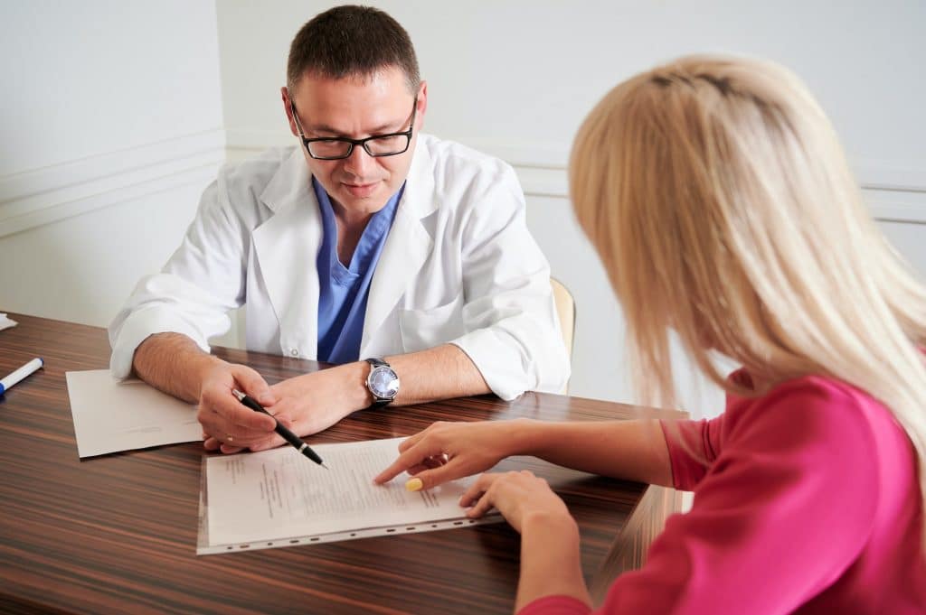 Female patient having consultation with doctor in clinic.